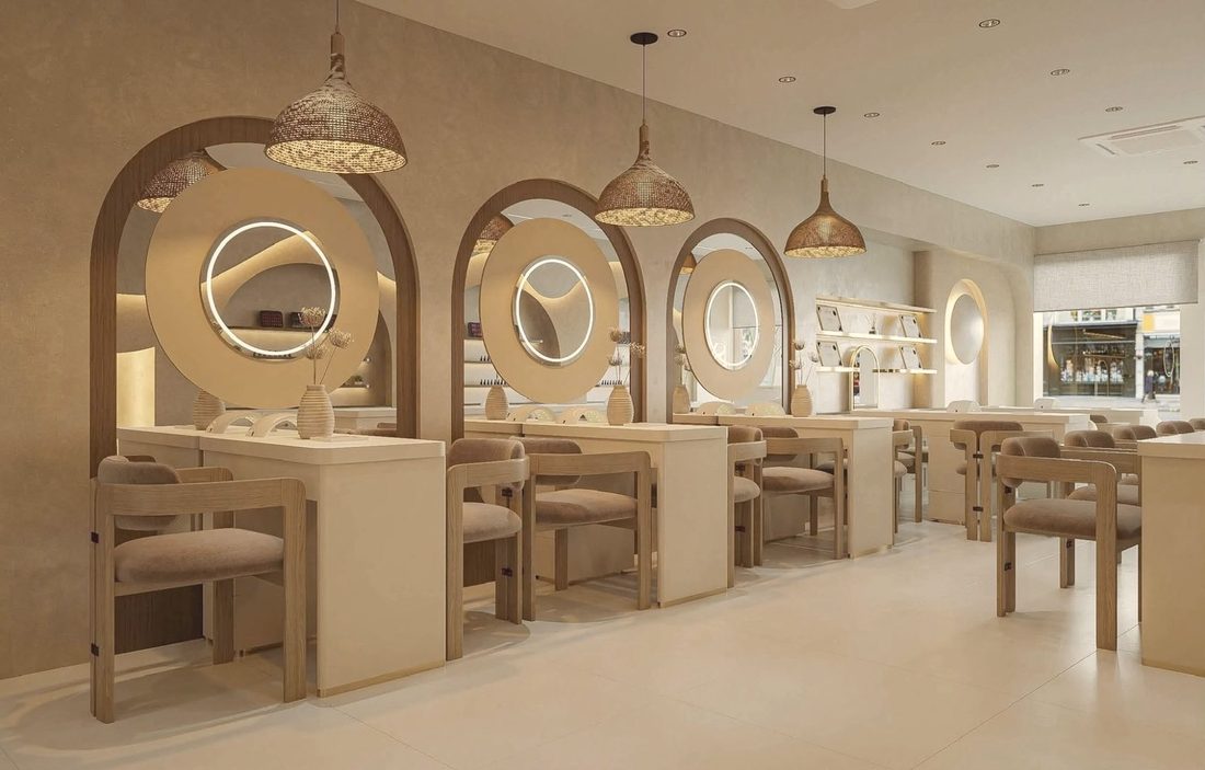 Nail desks with round ring-lit mirrors and rattan pendant lights